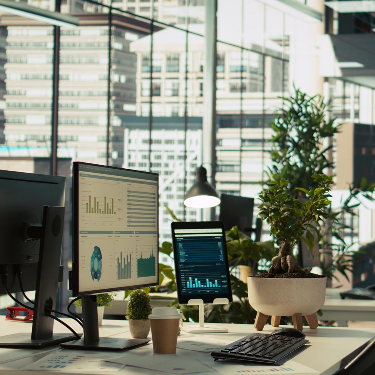 Modernes Büro mit mehreren Monitoren, Pflanzen und urbaner Arbeitsatmosphäre